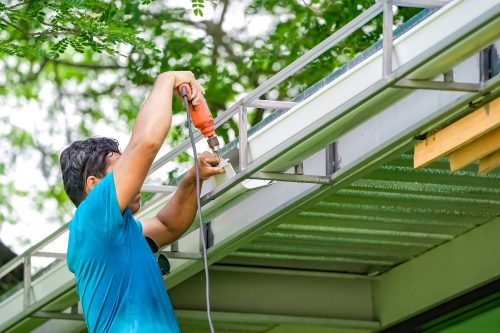 Asian worker screw, screwdriver to create and repair the rooftop water drain.