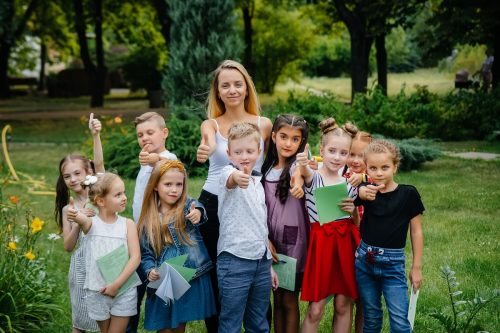 A teacher teaches a class of children in an outdoor Park. Back to school, learning during the pandemic